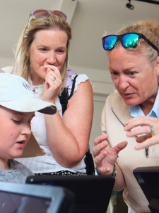 Picture of Monica talking to girl and parent over a microscope