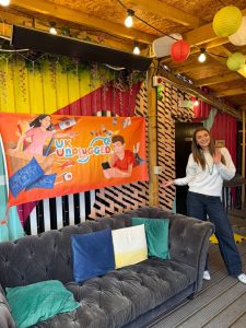 Meg standing next to a sign that says UK Unplugged