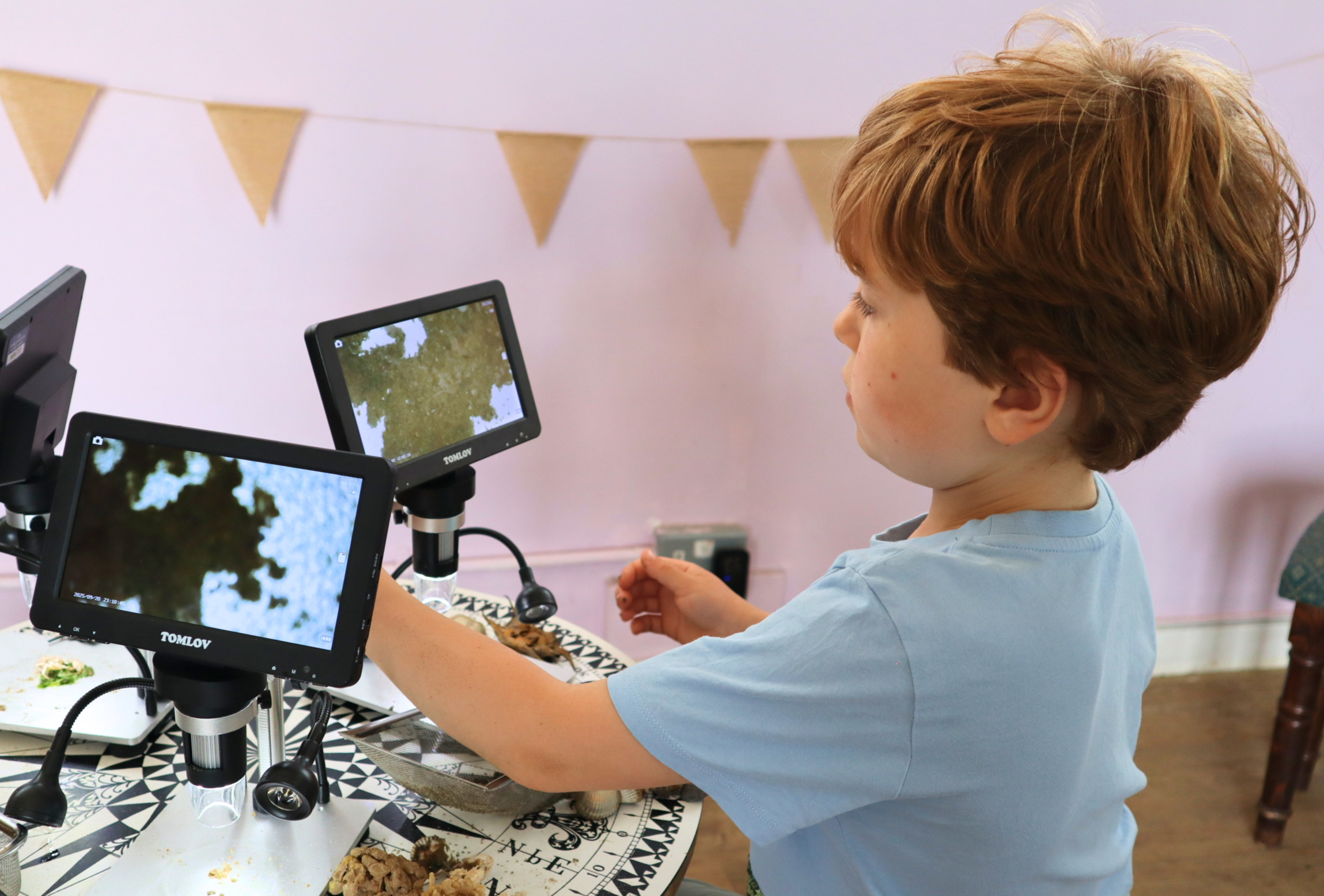 Boy looking at sand throught a microscope